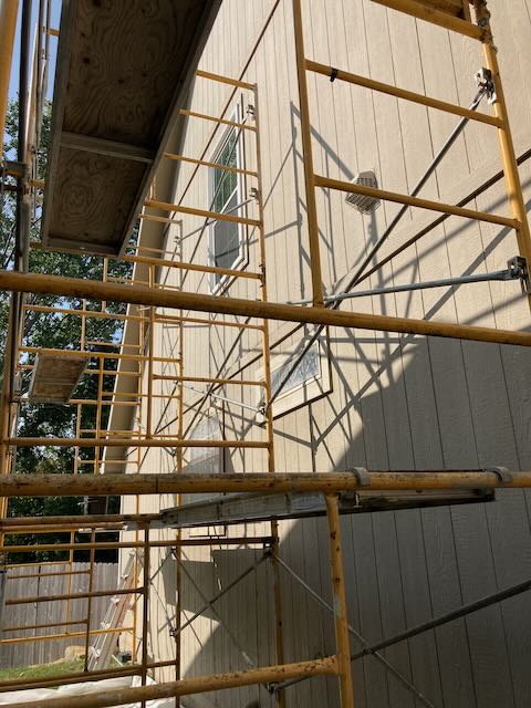 A picture of scaffolding set up next to a two story house.